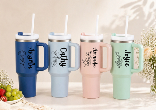 Four colorful tumblers with handles and names engraved on them, set against a neutral background.