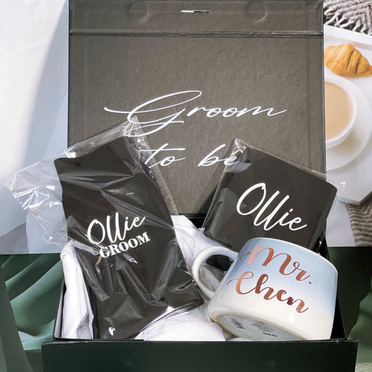 A gift box for the groom, with personalized text on the inside and outside of the box, including a black stubby holder, a pair of personalized socks, and a mug with 'MR. CHEN' written on it.