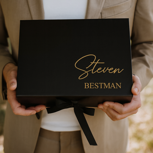 Person holding a black box with 'Steven Bestman' written on it, wearing a beige suit.