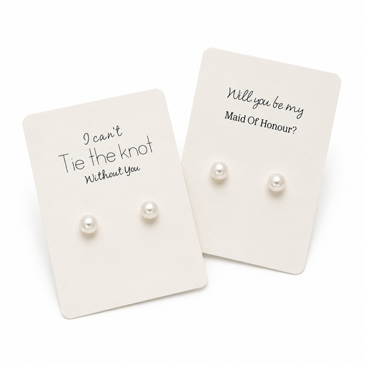 Pearl earrings on cards with personalized messages on a white background
