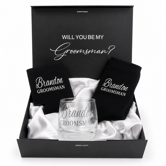 Groomsman proposal box with glass, black shirt, and black card inside a black box.