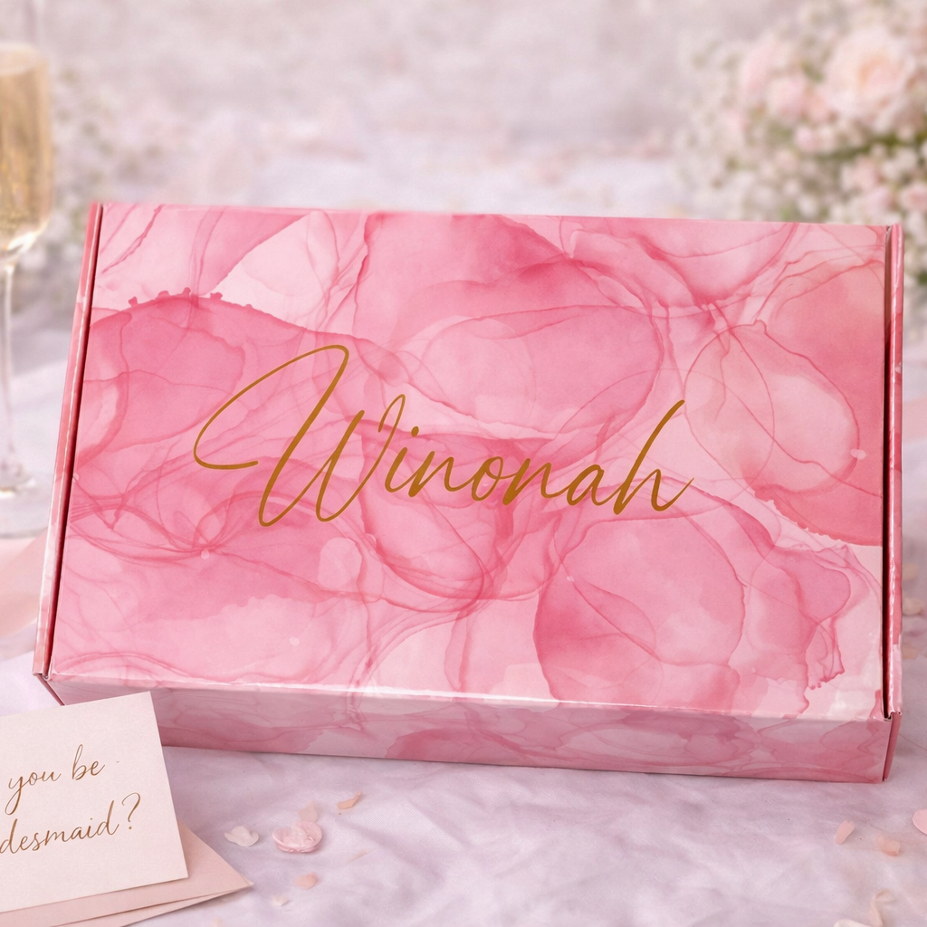 Pink floral box with 'Winonah' branding, champagne flute, card, and ring on a decorative background.