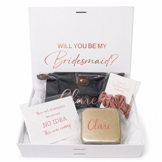 Gift set with 'Will you be my bridesmaid?' question and personalized items in a box.