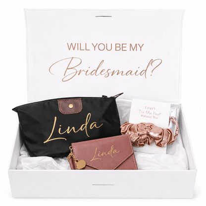 Gift set with 'Will You Be My Bridesmaid?' card, black pouch, pink wallet, and hair accessories in a box.