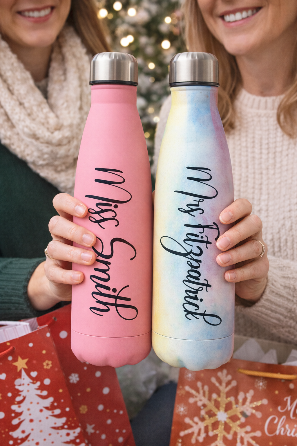Two people holding personalized water bottles with names 'Miss Smith' and 'Mrs. Fitzgerald' against a festive background.