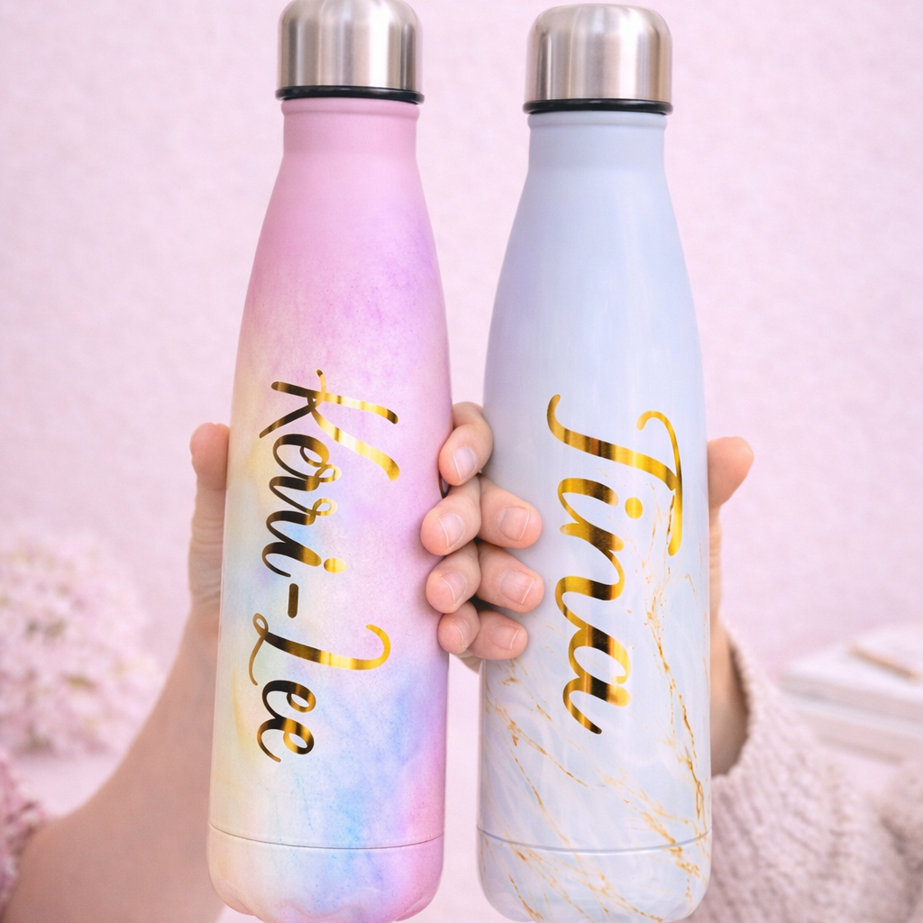 Two gradient water bottles held by a person with names written on them against a pink background.