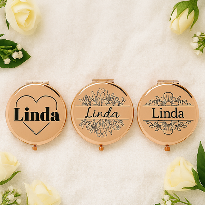 Three rose gold compact mirrors with 'Linda' engraving on a white background with flowers.