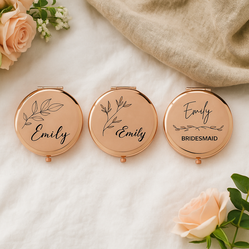 Three rose gold compact mirrors with 'Emily' and 'Bridesmaid' text on a light background with flowers.