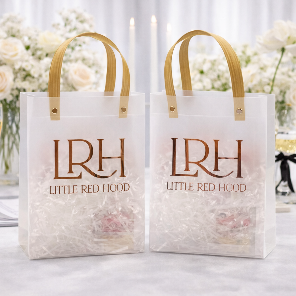 Two white gift bags with 'LRH Little Red Hood' branding on a blurred floral background.