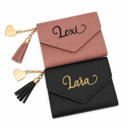 Two small wallets, one pink and one black, with 'Lexi' and 'Lara' embroidered on them, each with heart-shaped charms.