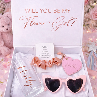 Gift set with 'Will You Be My Flower Girl?' message, sunglasses, scrunchie, and heart-shaped keychain in a box.