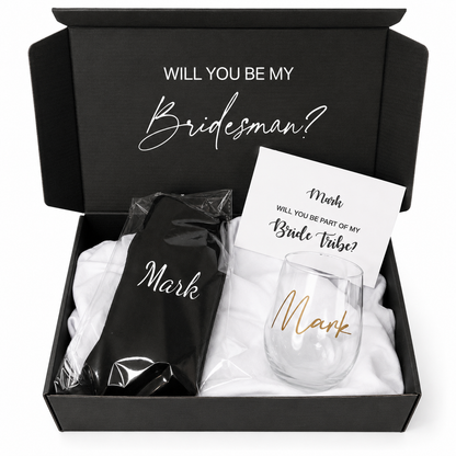 Gift set with a black shirt, white towel, and wine glass in a box with 'Will you be my Bridesman?' text.