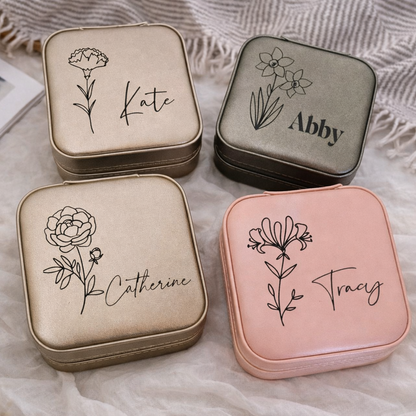 Four small square containers with floral designs and names engraved on a textured surface.