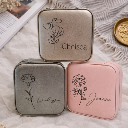 Three small travel cases with floral designs and names on a textured surface.