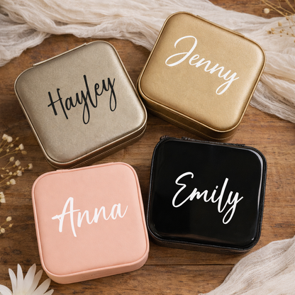 Four square containers with names 'Hayley', 'Jenny', 'Anna', and 'Emily' on a wooden surface with flowers.